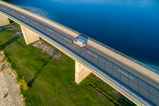 Aerial view of a delivery van driving on the bridge in summer.