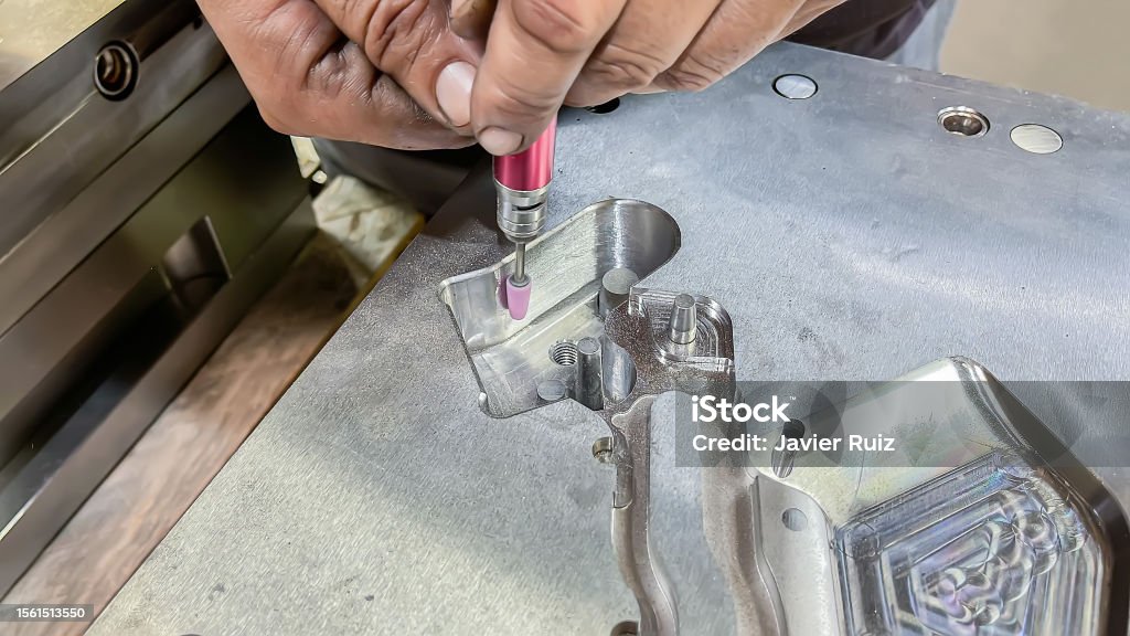 Trying Setter Injection A Toolmaker Adjusting A Plastic Injection Mold With A Grinder ...