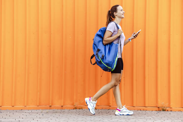 istock Young woman going back home from training with a phone in her hand 1561531286