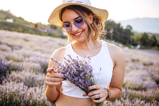 Young woman having fun in lavender field during sunset