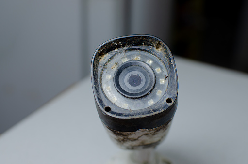 Detail of an aged and dirty security camera, evidencing the reminder of its replacement and maintenance to ensure continued security.