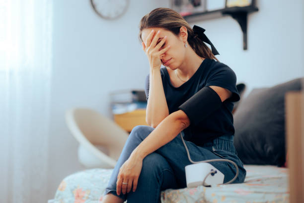 Femme prenant sa tension artérielle se sentant nauséeuse et malade - Photo