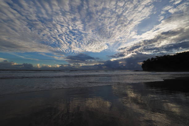 Sunset on Playa El Coco, Nicaragua. Sunset over beach of Playa El Coco, Nicaragua, with colorful cloudscape reflected in coastal water. el coco stock pictures, royalty-free photos & images