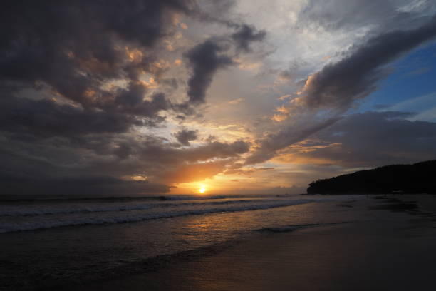 Sunset on Playa El Coco, Nicaragua. Sunset over beach of Playa El Coco, Nicaragua, with colorful cloudscape reflected in coastal water. el coco stock pictures, royalty-free photos & images