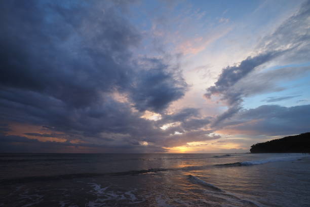 Sunset on Playa El Coco, Nicaragua. Sunset over the beach of Playa El Coco, Nicaragua, with a colorful cloudscape reflected in the coastal water. el coco stock pictures, royalty-free photos & images