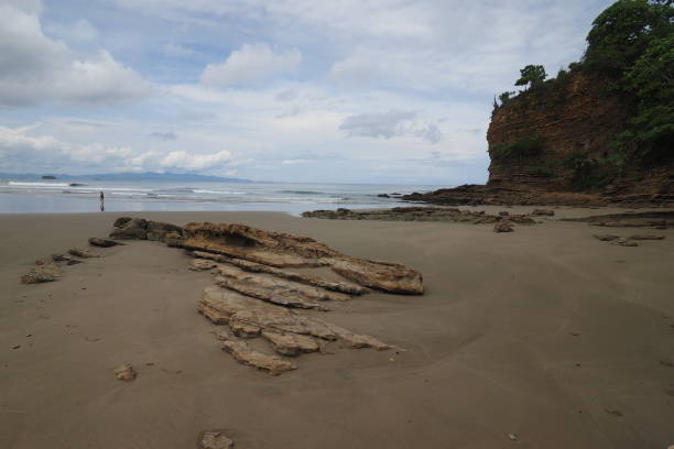 El Coco Beach, Nicaragua. Playa El Coco, Nicaragua, on sunny summer day showing its beach, rocks, vegetation and cloudscape. el coco stock pictures, royalty-free photos & images