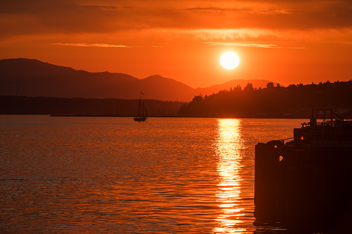 Seattle, USA - Jun 26, 2023: Sunset over Elliott Bay on the waterfront with the Seattle Tall Sailing Ship The Bay Lady.