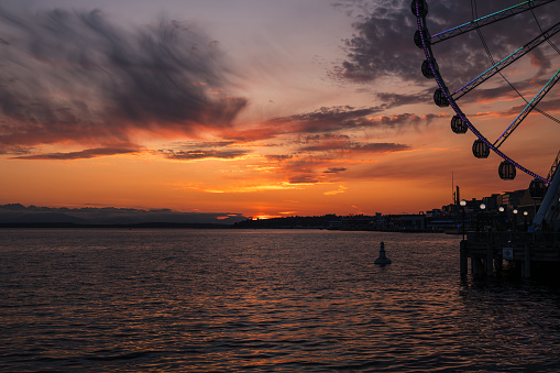 Seattle, USA - Jun 21, 2023: Sunset over Elliott Bay on the waterfront with the Seattle Great Wheel.