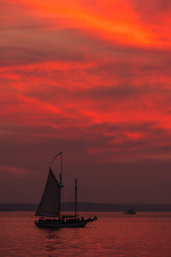 Seattle, USA - Oct 6th, 2022: A vivid sunset over Elliott bay with seattles tallest ship the Bay Lady at the Harbor Marina.