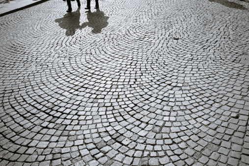 Shadows of people walking in Verona's square