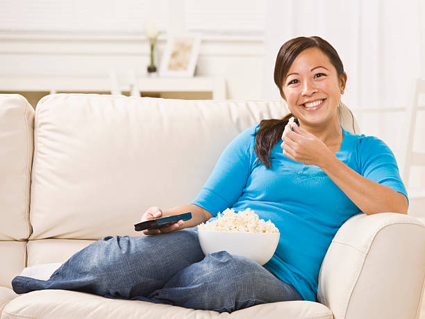 istock Beautiful Woman on the Couch Eating Popcorn 156196231