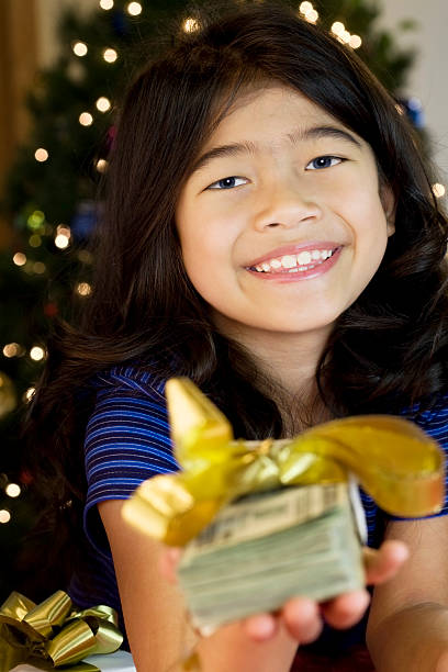 bambina con la pila di contanti a natale - twenty dollar bill currency dollar stack foto e immagini stock