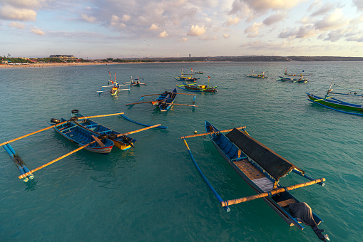 Traditional fisherman wooded boat in Bali island near the beach on sunset time, Indonesia, Asia