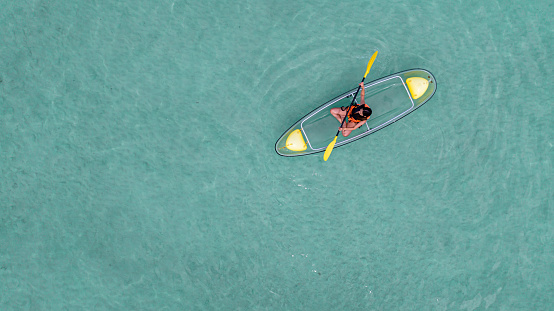 Asian woman travel Pataya by use kayak boat togather on on clean sea water from top view in Thailand