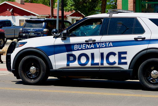 Buena Vista, Colorado, USA - July 21, 2023: A Buena Vista Police officer in a police cruiser waits at a stoplight in downtown Buena Vista.