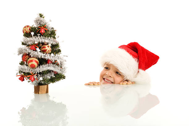 menino feliz com pequena árvore de natal - christmas child little boys peeking imagens e fotografias de stock
