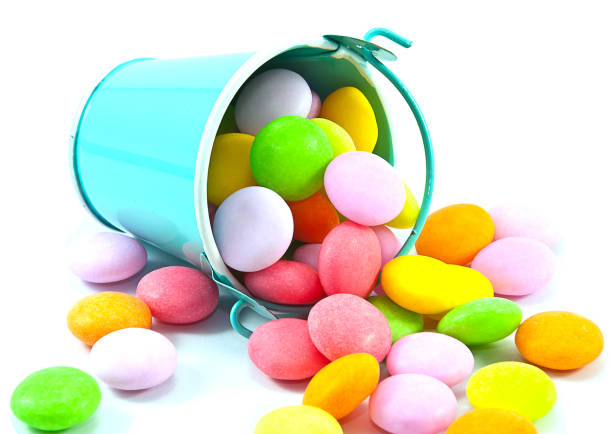istock Bucket of colorful candy on white background 1562031102