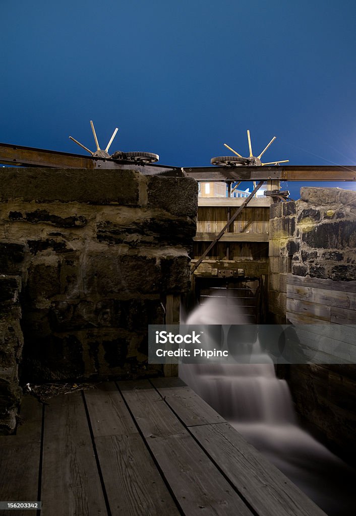 leaky lock Water spraying through an old lock at night in Lowell MA Gear - Mechanism Stock Photo