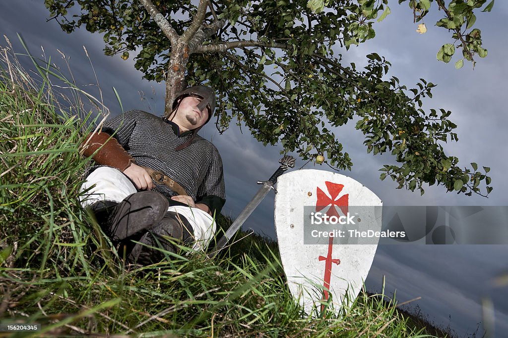Knight resting A medieval knight resting against an apple tree. Knight - Person Stock Photo