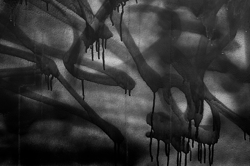 Black and white image of graffiti with drips on wall