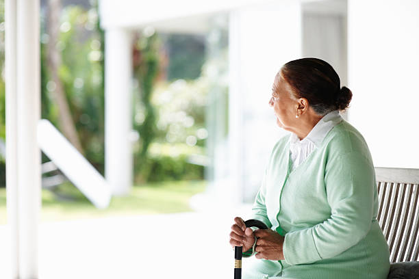 istock Elderly woman sitting isolated on a bench 156205103