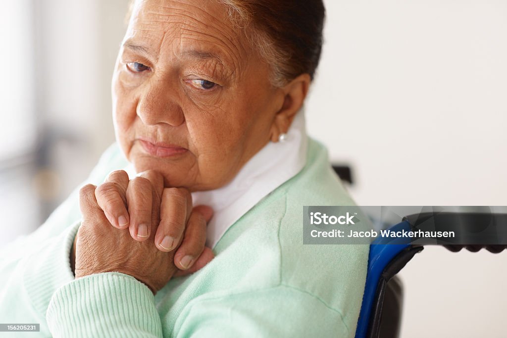 Deprimida mujer de edad avanzada en una silla de ruedas - Foto de stock de Silla de ruedas libre de derechos
