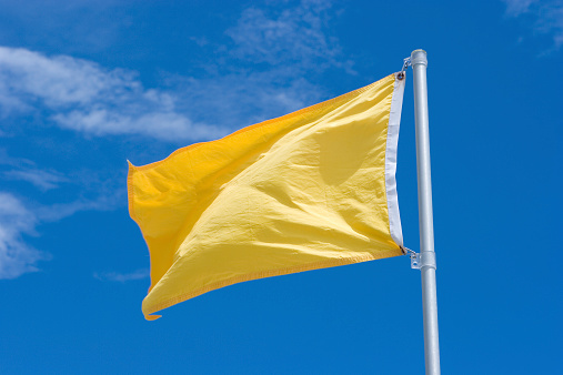 Yellow Warning Flag at the Beach Before a Storm