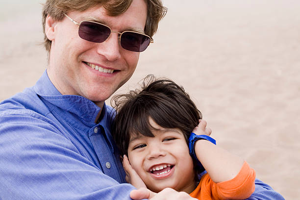 istock Father and son laughing together on beach 156205715