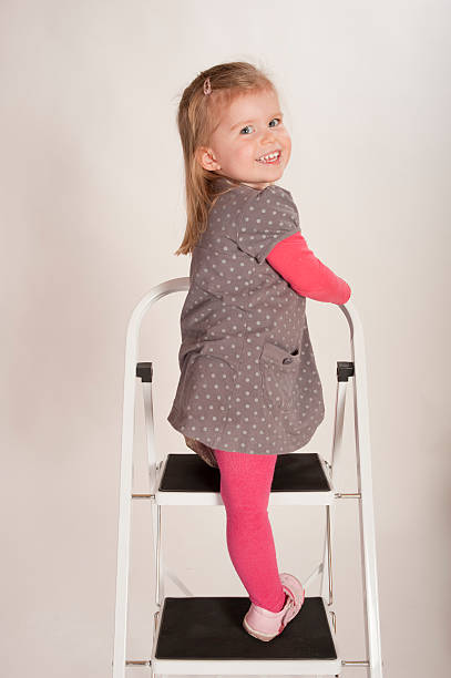 istock young girl climbing stepladder 156206768