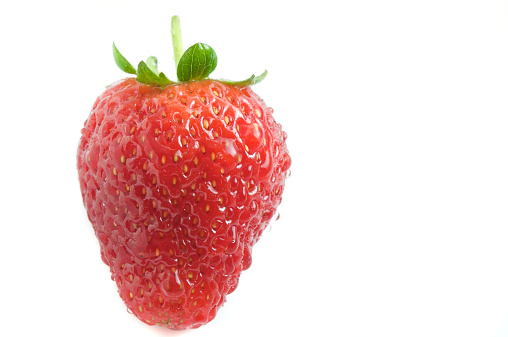 Fresh juicy strawberry covered in water droplets isolated on a white background