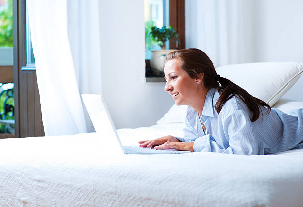 Femme travaillant sur un lit - Photo