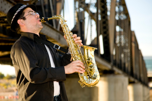 A saxophonist plays outdoors in