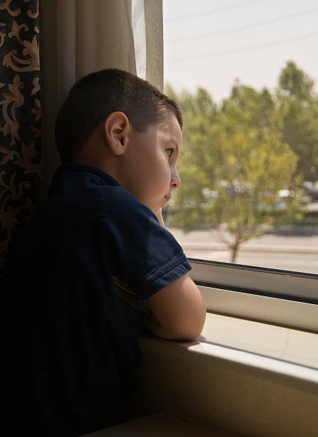 istock Little Boy Looking Out The Window 156208504