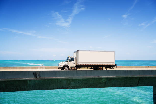 Delivery white truck  driving over the seven mile bridge in Marathon Key, Florida Delivery white truck  driving over the seven mile bridge in Marathon Key, Florida miami marathon stock pictures, royalty-free photos & images