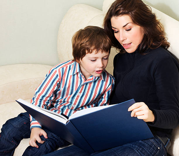 istock A woman and young boy reading a large book together 156210081