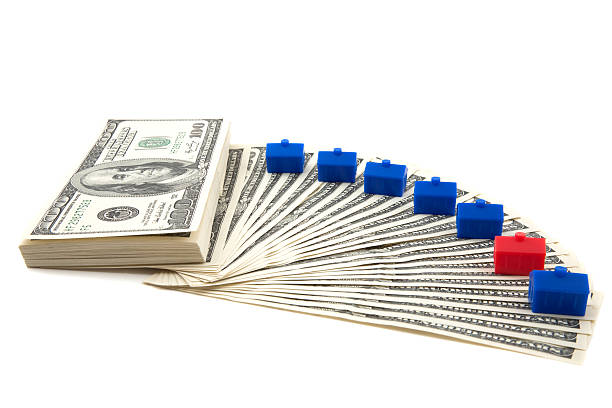 Spread of cash, with blue houses lined up stock photo