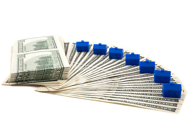 Spread of cash, with blue houses lined up stock photo