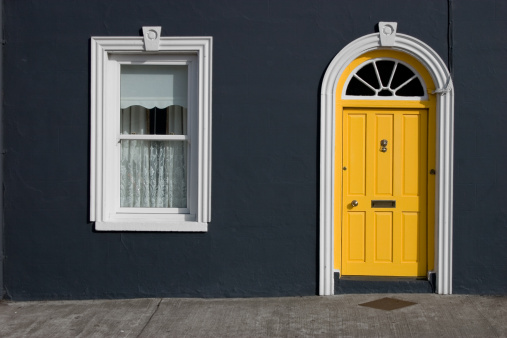 Typical yellow door with white window and black wall