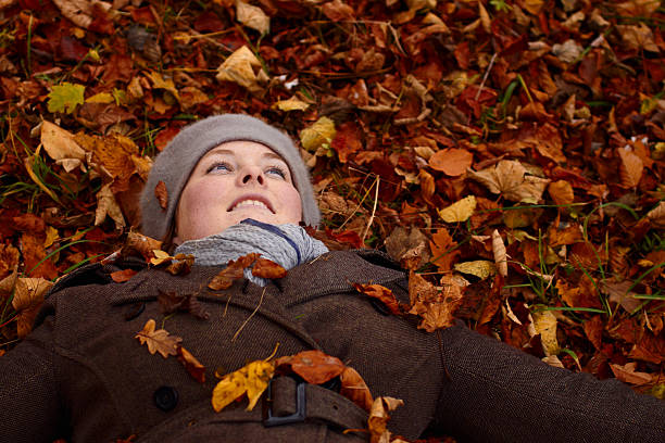 istock Cute young woman lying down on autumn leaves 156212753