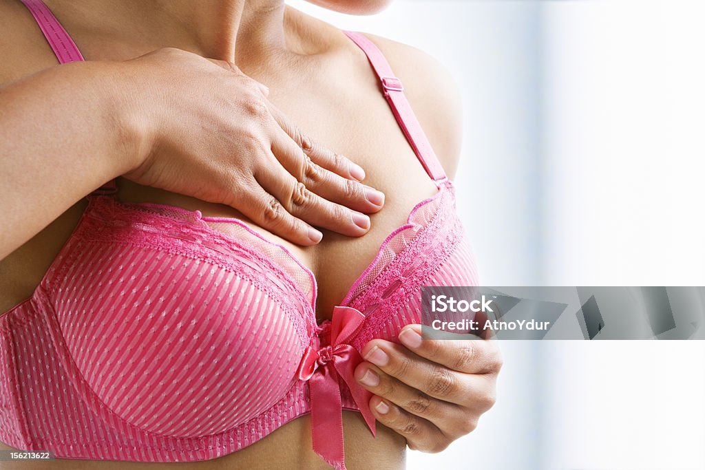 Woman doing self breast examination Woman doing self breast examination using pink bra Breast Examination Stock Photo