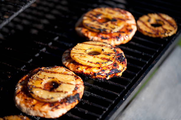 Perfectly grilled pineapple rings sit atop turkey patties.  Both have been slathered with teriyaki sauce during the grilling process thereby imparting a unique flavor as the sweet of the pineapple merges with the tang of the teriyaki sauce.  Very shallow depth of field was used with the focus being on the middle burger/pineapple combination.
