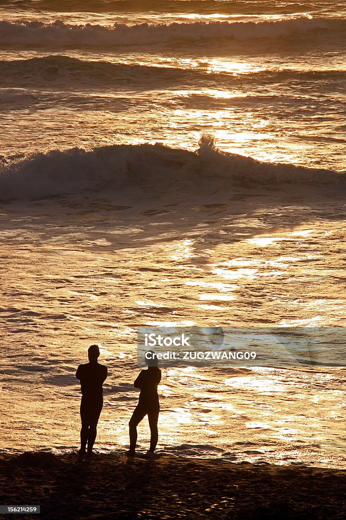 Hombre y mujer en la playa al atardecer - Foto de stock de Adulto libre de derechos