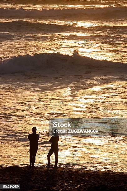 Hombre Y Mujer En La Playa Al Atardecer Foto de stock y más banco de imágenes de Adulto - Adulto, Agua, Aire libre