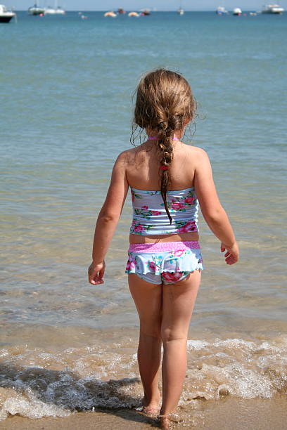 beach babe young girl walking into the sea on holiday in dorset backside for a girl on the beach stock pictures, royalty-free photos & images