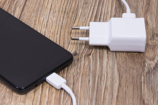 istock Black smartphone and charger using to charge empty battery. Various devices charging concept 1562172176