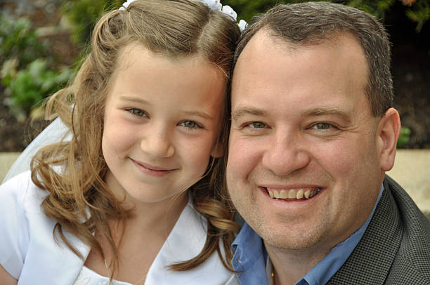 first communion day a father and daughter smile on her first communion day bride hugging father on wedding day stock pictures, royalty-free photos & images