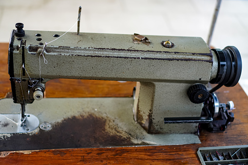 A close-up picture shows a vintage metal sewing machine for home weaving.
