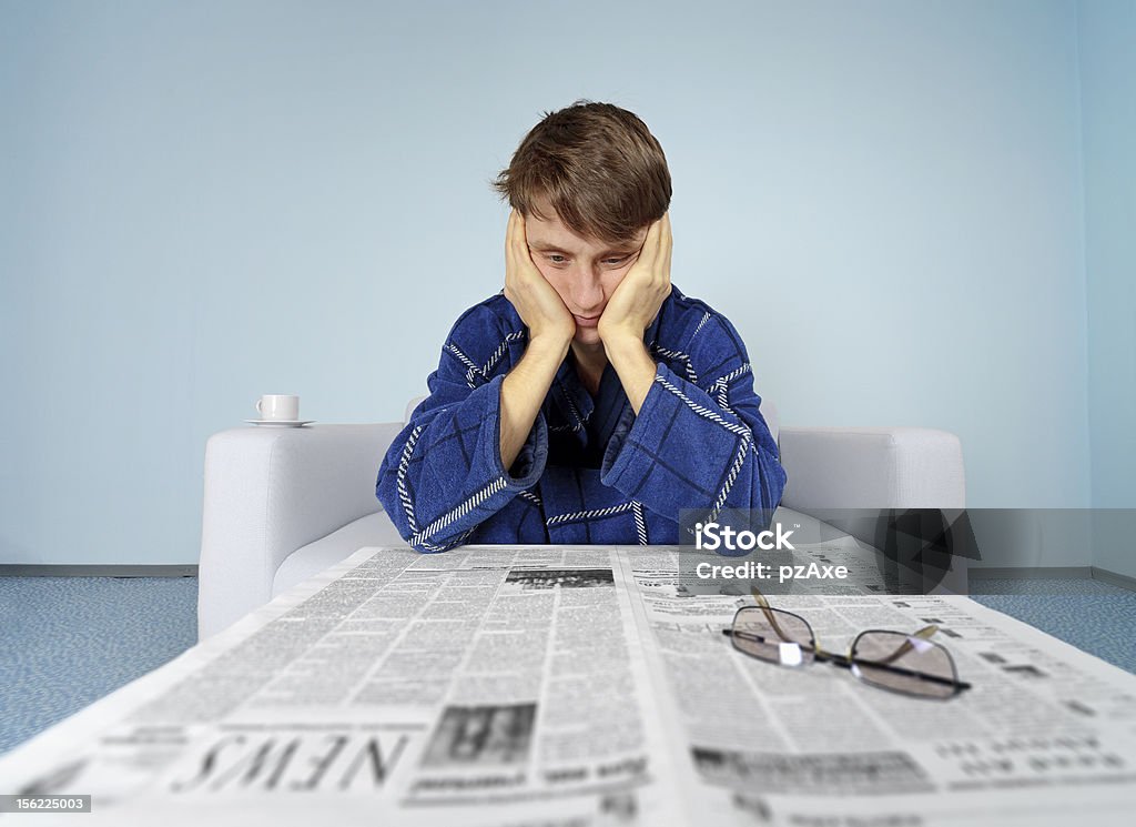 Man with newspaper - hard find a job Bad news from the newspaper - hard find a job Adult Stock Photo