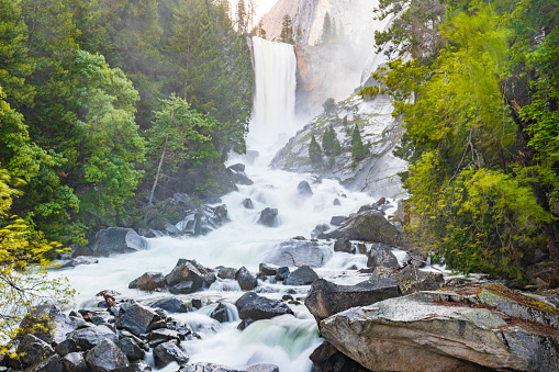 Powerful flowing river rapids with waterfall in nature. Vernal Falls, Yosemite Valley National Park during peak snowmelt 2023, California, USA.