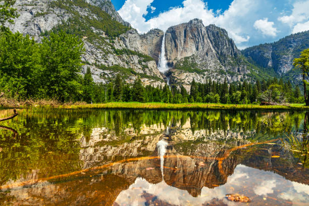 Yosemite Falls peak flow from snowmelt with reflection on still water